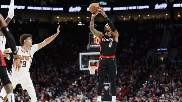 Dec 14, 2021; Portland, Oregon, USA; Portland Trail Blazers point guard Damian Lillard (0) shoots the ball over Phoenix Suns small forward Cameron Johnson (23) during the second half at Moda Center. Mandatory Credit: Soobum Im-USA TODAY Sports